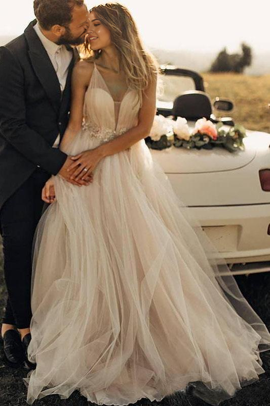 Vestido de novia bohemio playero con escote en V profundo y tirantes finos de tul.